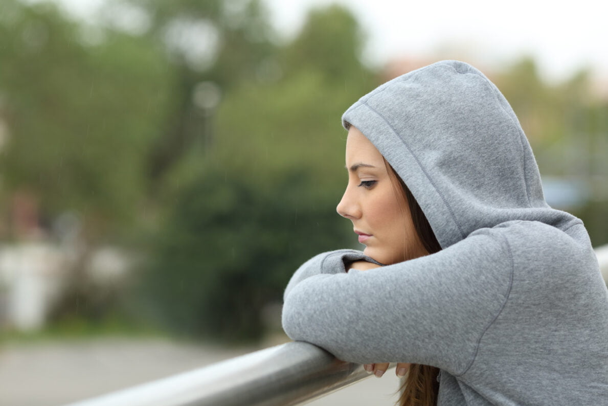 Sad woman outside wearing hoodie 